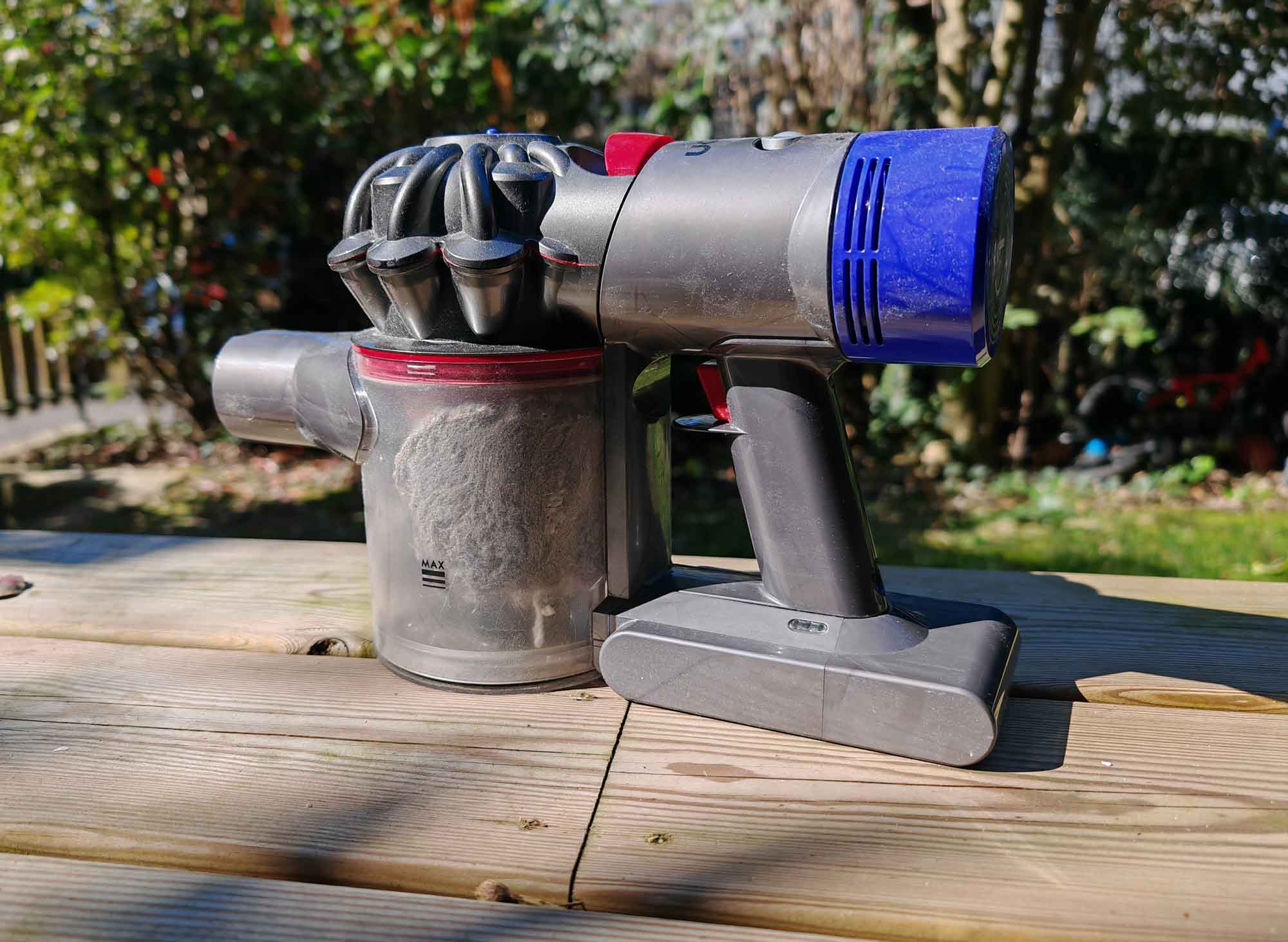 Le collecteur du Dyson V8 rempli de poussière et de débris avant vidage. (c) Labo Maison